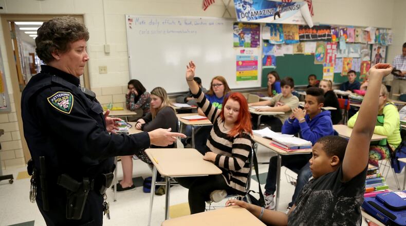 Kettering Police school resource officer Carla Sucher talks with seventh-grade students in a health class at Van Buren Middle School about alcohol abuse. Many schools rely on the presence of SROs to boost security. LISA POWELL / STAFF