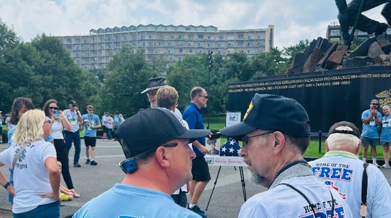Stephen Lewis, 75, is a Vietnam veteran and Fairfield resident who on Aug. 10, 2024, took an Honor Flight trip out of the Dayton hub to Washington, D.C., with his son, Tim Lewis, of Fairfield. Pictured is the younger Lewis, left, talking to his dad in front of the World War II memorial. An easel in the background holds a photo of Stephen Lewis' dad, Earl E. Lewis, a WWII veteran and Fairfield resident who died in 2016. It was part of the Honor Flight's Honoring Yesterday's Heroes program. PROVIDED