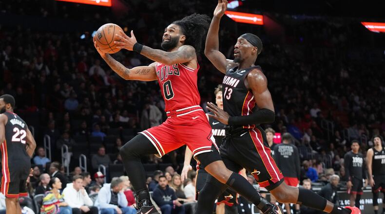 Chicago Bulls guard Coby White (0) drives to the basket as Miami Heat center Bam Adebayo (13) defends during the second half of an NBA basketball game, Sunday, Feb. 1, 2026, in Miami. (AP Photo/Lynne Sladky)