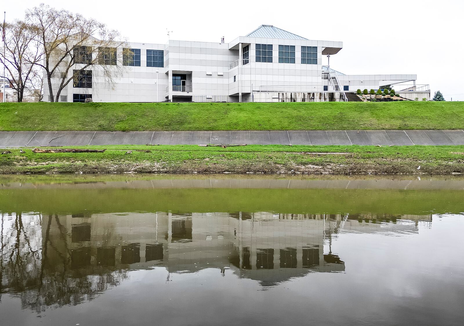 Fitton Center for Creative Arts is reflected in the Great Miami River Wednesday, April 10, 2024 in Hamilton. NICK GRAHAM/STAFF