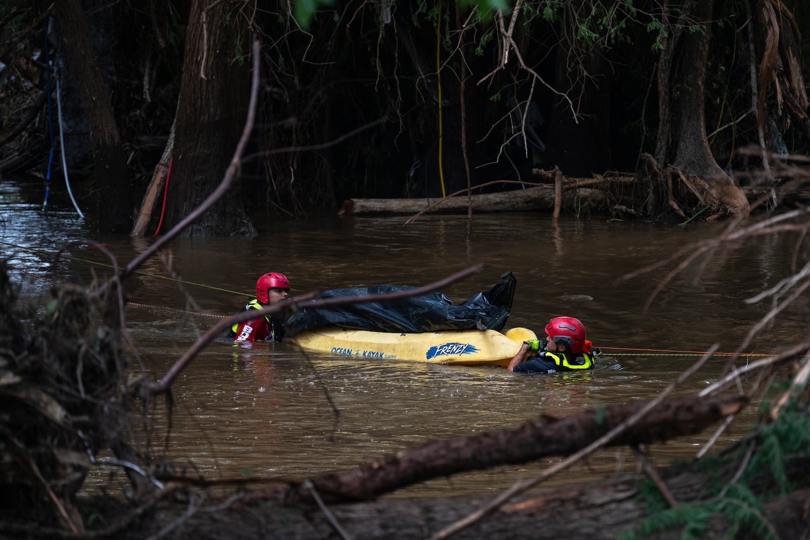 Firefighters from Ciudad Acuña, Mexico, perform a water recovery of a body in a portion of the flooded Guadalupe River after a flash flood swept through the area Monday, July 7, 2025, in Ingram, Texas. (AP Photo/Eli Hartman)