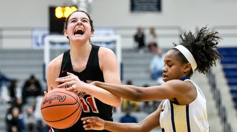 Lakota West’s Madisyn Oxley drives to the hoop under pressure from Walnut Hills’ Regan Anderson during Wednesday night’s Division I regional semifinal at Fairmont’s Trent Arena. Oxley’s Firebirds won 60-31. NICK GRAHAM/STAFF