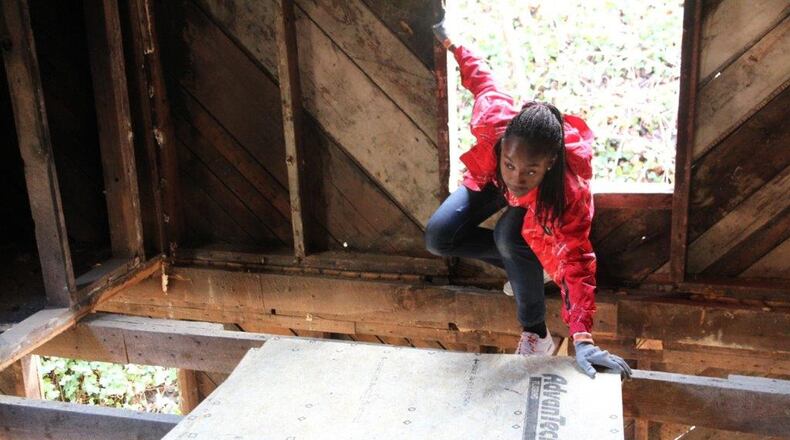 Miami University Middletown student Janart Addo works with other classmate volunteers last week in Gatlinburg, Tennessee to rebuild a burned down home. Addo, who is an English-learning freshmen from Ghana, understood the homeowners pain as she has twice lost her west African home to fire. CONTRIBUTED