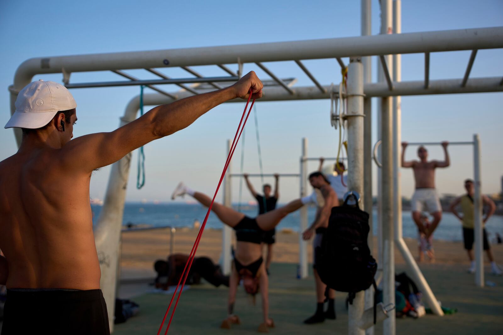People work out in an open-air gym next to the beach in Barcelona, Spain, Tuesday, June 25, 2025. (AP Photo/Emilio Morenatti)