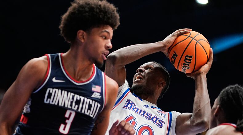 Kansas forward Flory Bidunga (40) shoots over UConn forward Jaylin Stewart (3) during the first half of an NCAA college basketball game Tuesday, Dec. 2, 2025, in Lawrence, Kan. (AP Photo/Charlie Riedel)