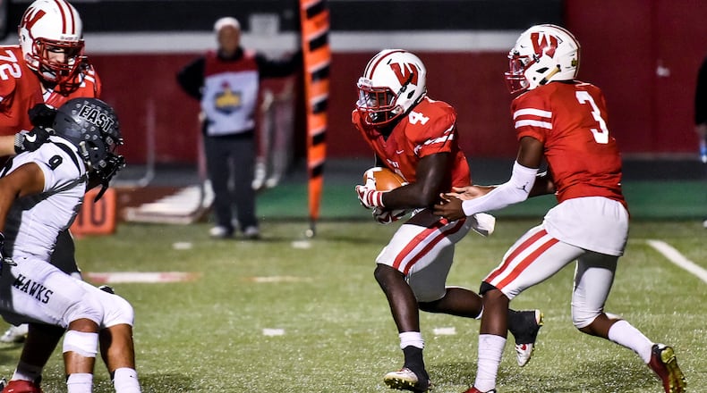 Lakota West quarterback MyJaden Horton (3) hands the ball off to David Afari (4) during their game against Lakota East Friday, Sept. 29 at Lakota West High School in West Chester Township. Lakota East won 35-0. NICK GRAHAM/STAFF