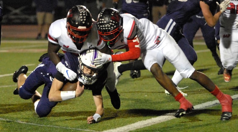 Lakota West's Cole Munday and Taebron Bennie-Powell (right) tackle an Elder ball carrier during a Division I regional semifinal game on Friday, Nov. 11, 2022. Bennie-Powell signed with Notre Dame on Wednesday, the first day of the national signing period. DAVID A. MOODIE/CONTRIBUTING PHOTOGRAPHER