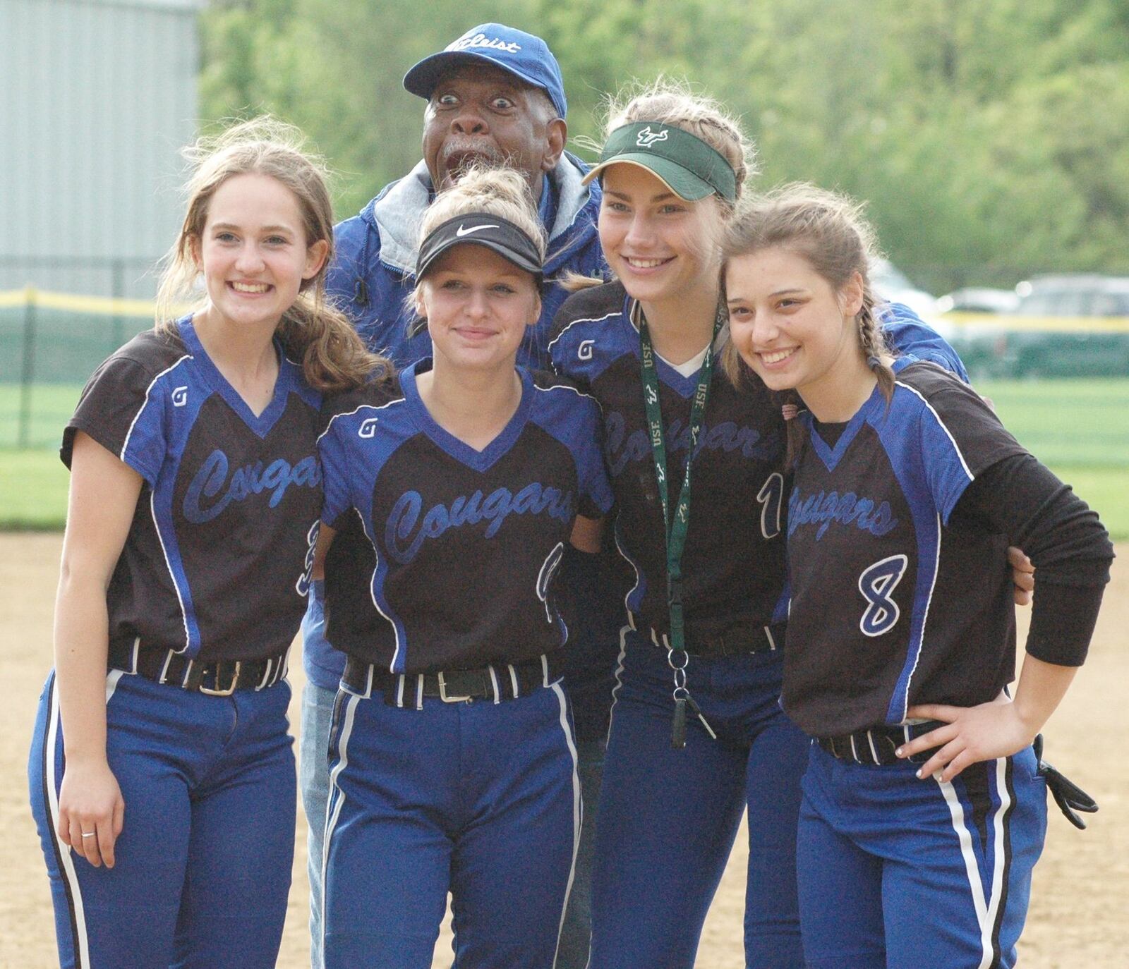 Cincinnati Christian athletic director Steve Gillens photobombs a group shot that includes (from left) Merrick Heid (3), Kirsten Clark (9), Jenna Monk (1) and Elizabeth Bowling (8) on Friday after a Miami Valley Conference Scarlet Division softball game against visiting Cincinnati Hills Christian Academy. CCS won 5-4. RICK CASSANO/STAFF