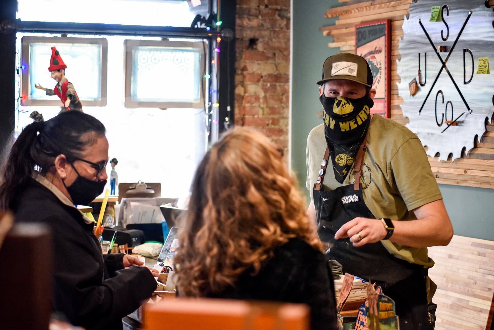 Justin Carder talks to customers Angie Mantell-Smith, left, and Stephanie Hart at Unsung Salvage Design Company Tuesday, Dec. 15, 2020 on Main Street in Hamilton. NICK GRAHAM / STAFF