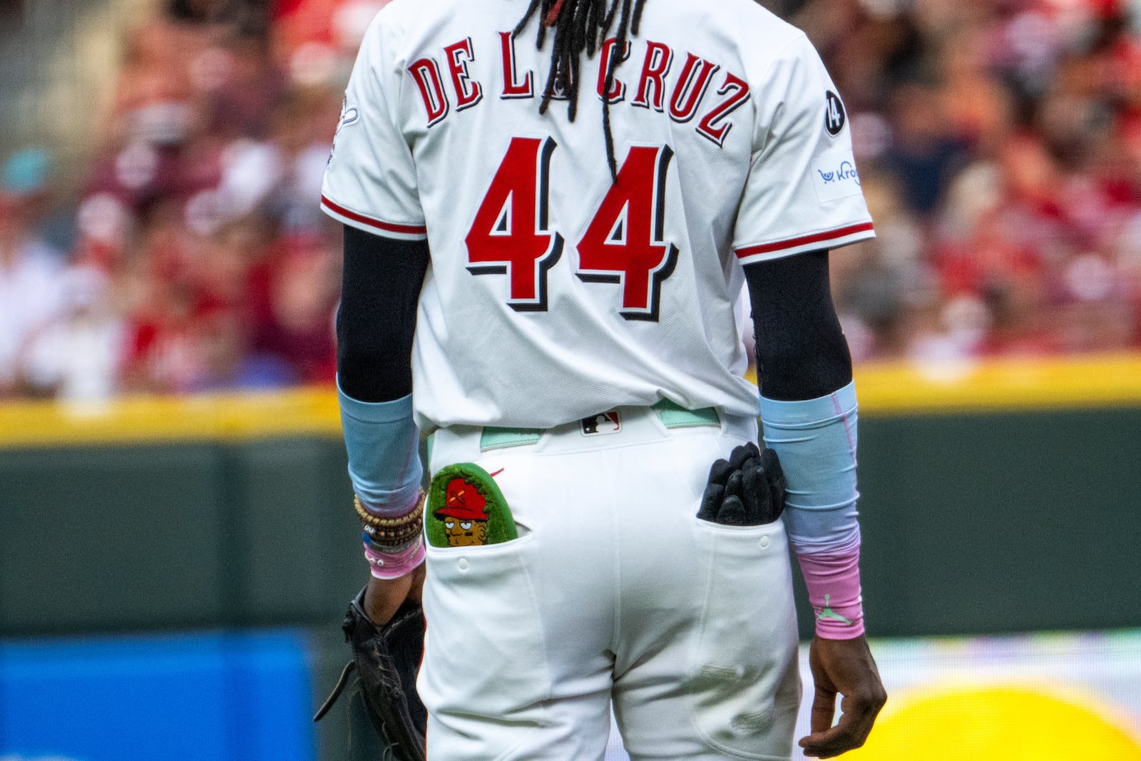 Cincinnati Reds shortstop Elly De La Cruz carries a custom sliding glove as a part of Players Weekend in the seventh inning of a baseball game against the Milwaukee Brewers, Saturday, Aug. 16, 2025, in Cincinnati. (AP Photo/Michael Swensen)