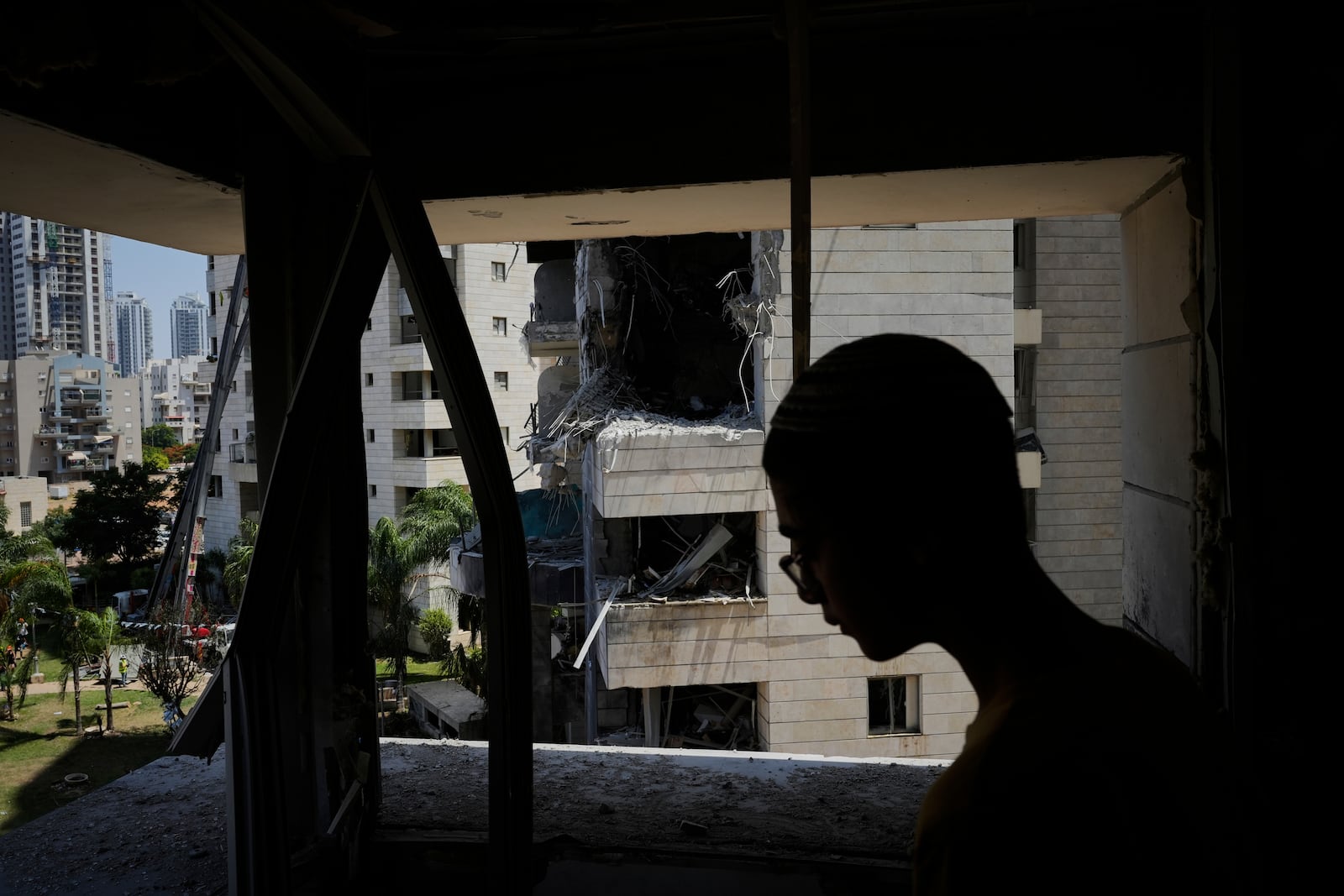 A man inspect the damage to a residential building hit by a missile launched from Iran, in Petah Tikva, Israel, Monday, June 16, 2025. (AP Photo/Baz Ratner)