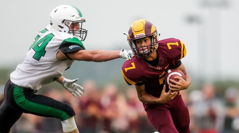 Ross quarterback C.J. Boze carries the ball trailed by Badin’s Evan Schlensker during their season opener football game Friday, Aug. 24, 2018, at Ross High School. Badin won 41-20. NICK GRAHAM/STAFF