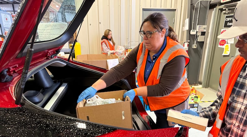 Employees at The Food Bank Inc. load food into a car on Thursday, Oct. 30, 2025 in Dayton, Ohio. (AP Photo/Patrick Aftoora-Orsagos)
