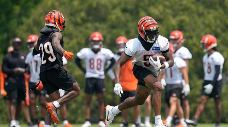 Cincinnati Bengals wide receiver Tee Higgins (5) runs after making a catch against cornerback Cam Taylor-Britt (29) during practice at the team's NFL football training facility, Tuesday, June 6, 2023, in Cincinnati. (AP Photo/Jeff Dean)