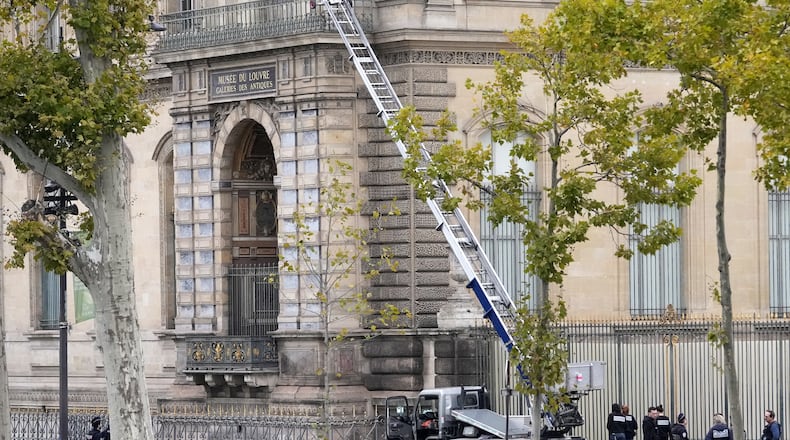Police officers work by a basket lift used by thieves Sunday, Oct. 19, 2025 at the Louvre museum in Paris. (AP Photo/Thibault Camus)