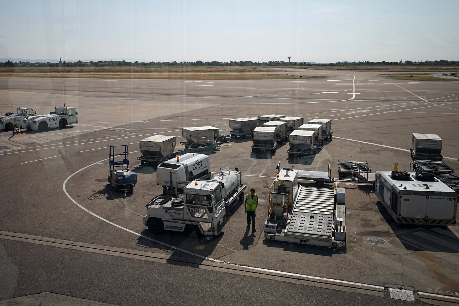 A worker walks on the tarmac at the Saint-Exupery airport, near Lyon, France, as French air traffic controllers launched a two-day strike to demand better working conditions, Friday, July 4, 2025. (AP Photo/Laurent Cipriani)