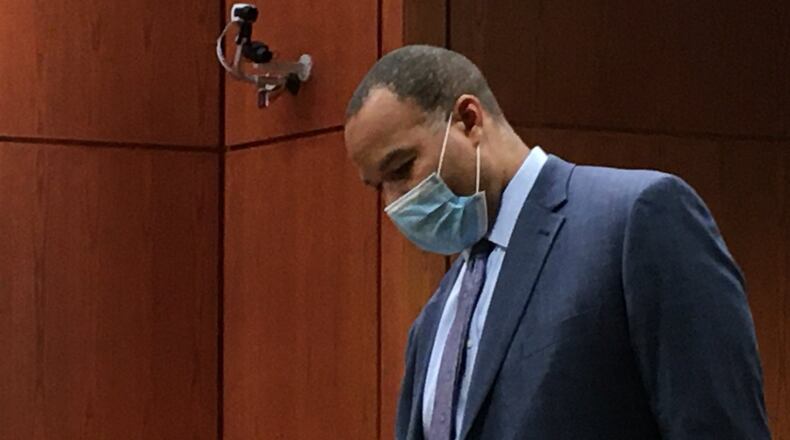 Attorney Lawrence Hawkins III takes with his client, an 16-year-old boy charged with murder in the shooting death of John Booker on May 11. The teen was in Butler County Juvenile Court Thursday for a hearing. LAUREN PACK/STAFF