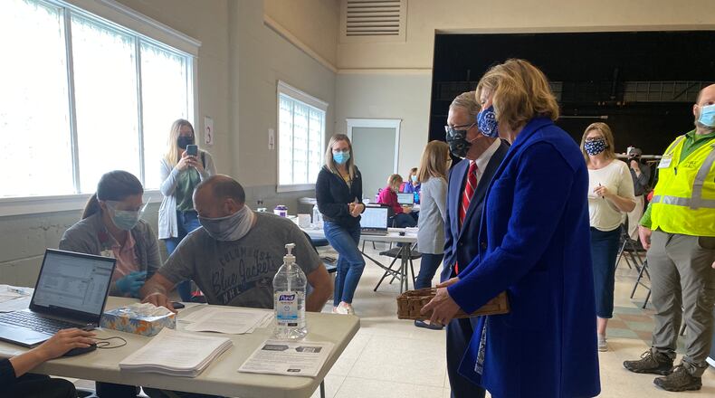 Ohio Gov. Mike DeWine and Ohio First Lady Fran DeWine (right) look on as Barry Gertner, 54, gets a COVID-19 vaccine at a vaccination clinic in Piqua. EILEEN McCLORY / STAFF