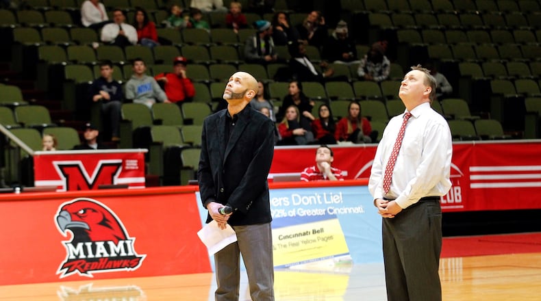 Chris Coles (left) and Miami University athletic director David Sayler watch a tribute video for Charlie Coles during halftime of a Jan. 22, 2014, basketball game at Millett Hall in Oxford. JOURNAL-NEWS FILE PHOTO