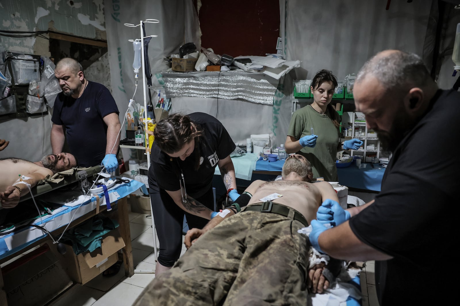 In this photo provided by Ukraine's 24th Mechanized Brigade press service, military medics give first aid to a wounded Ukrainian soldiers at a medical stabilisation point in Donetsk region, Ukraine, Friday, July 25, 2025, (Oleg Petrasiuk/Ukraine's 24th Mechanized Brigade via AP)