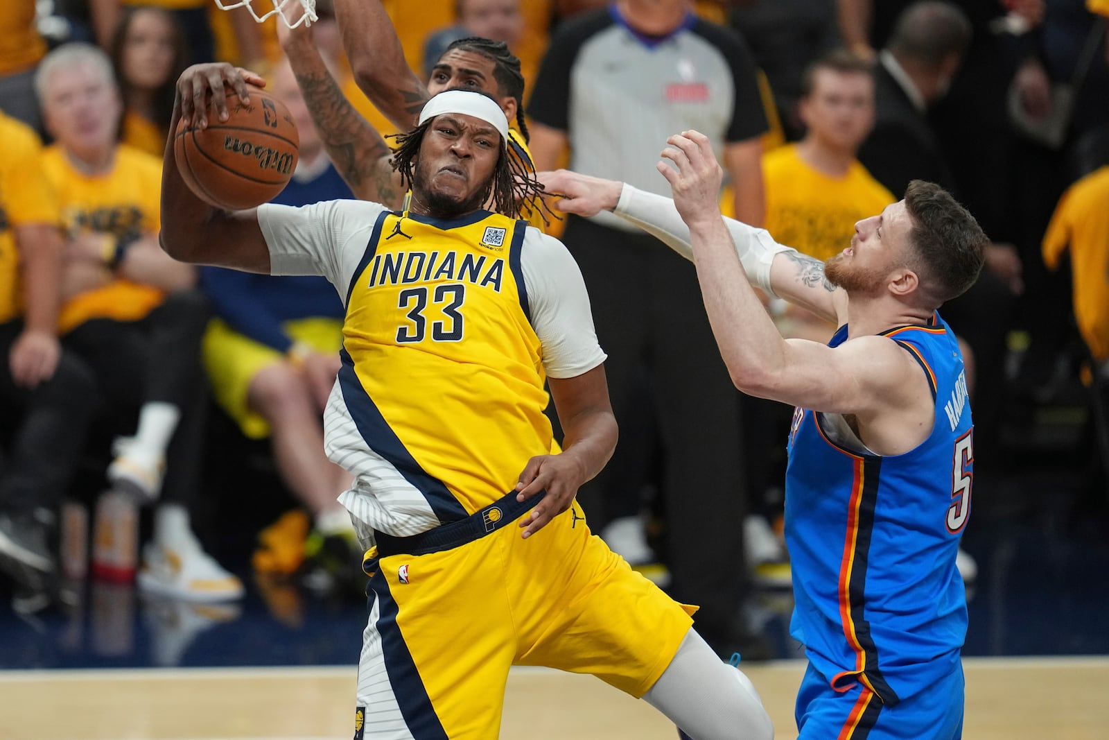 Indiana Pacers center Myles Turner (33) rebounds over Oklahoma City Thunder center Isaiah Hartenstein during the first half of Game 6 of the NBA Finals basketball series, Thursday, June 19, 2025, in Indianapolis. (AP Photo/Michael Conroy)