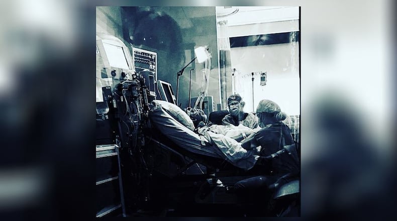 Lindsey Fairchild, an ICU nurse in Florida, took this photo of her father, Wayne Oney, on the day he died at Atrium Medical Center. His wife, Lisa, can be seen in the window reflection. SUBMITTED PHOTO
