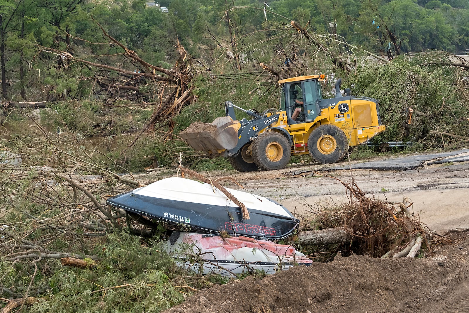 Crews work to clear debris from the Cade Loop bridge along the Guadalupe River on Saturday, July 5, 2025, in Ingram, Texas. (AP Photo/Rodolfo Gonzalez)