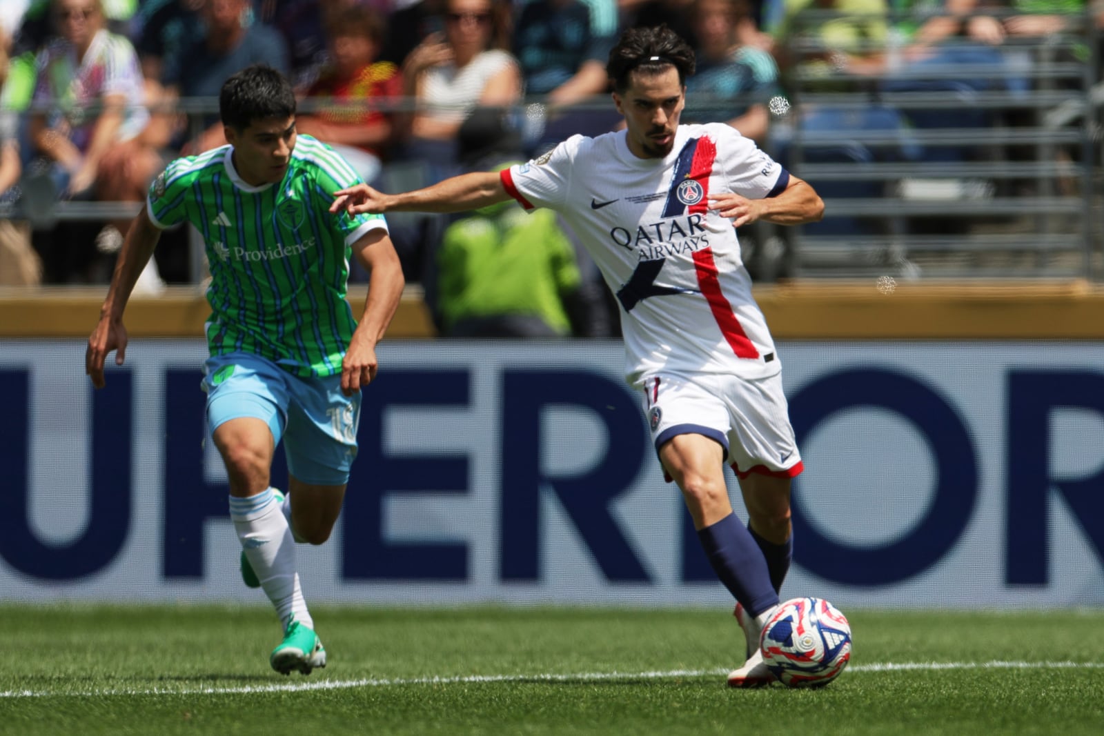 Paris Saint-Germain's Vitinha, right, passes the ball as Seattle Sounders' Obed Vargas looks on during the Club World Cup Group B soccer match between Seattle Sounders and PSG in Seattle, Monday, June 23, 2025. (AP Photo/Ryan Sun)