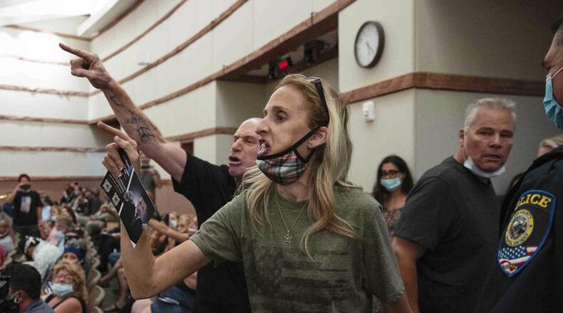 In this Aug. 12, 2021 file photo, protesters against a COVID-19 mandate gesture as they are escorted out of the Clark County School Board meeting at the Clark County Government Center, in Las Vegas. The nation's school boards are asking President Joe Biden for federal assistance to investigate and stop a growing number of threats made against their members, on Thursday, Sept. 30. (Bizuayehu Tesfaye/Las Vegas Review-Journal via AP, File)