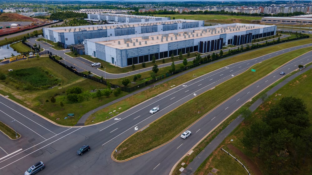 FILE - Cars drive past data centers that house computer servers and hardware required to support modern internet use, such as artificial intelligence, in Ashburn, Virginia, July 16, 2023. (AP Photo/Ted Shaffrey, File)