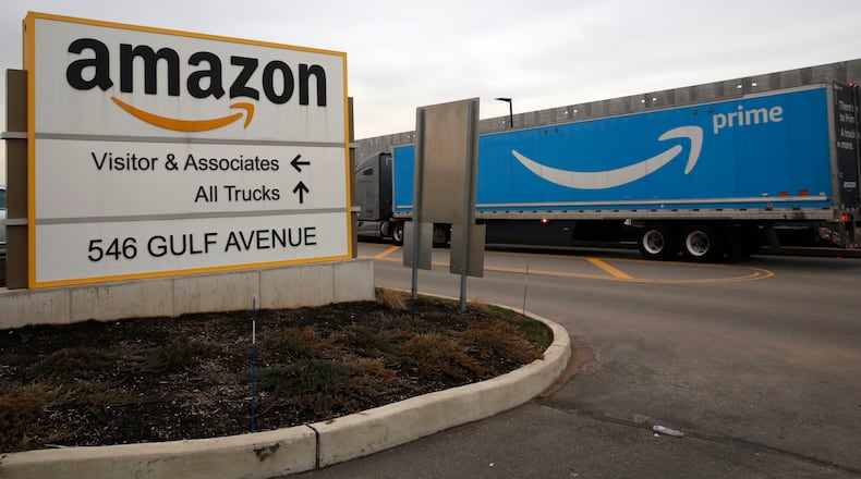 FILE - An Amazon Prime truck passes by a sign outside an Amazon fulfillment center March 19, 2020 in Staten Island, N.Y. (AP Photo/Kathy Willens, File)