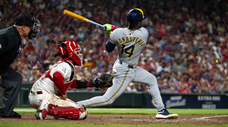 Milwaukee Brewers Andruw Monasterio (14) hits a home run in the 10th inning of a baseball game against the Cincinnati Reds, Saturday, Aug. 16, 2025, in Cincinnati. (AP Photo/Michael Swensen)