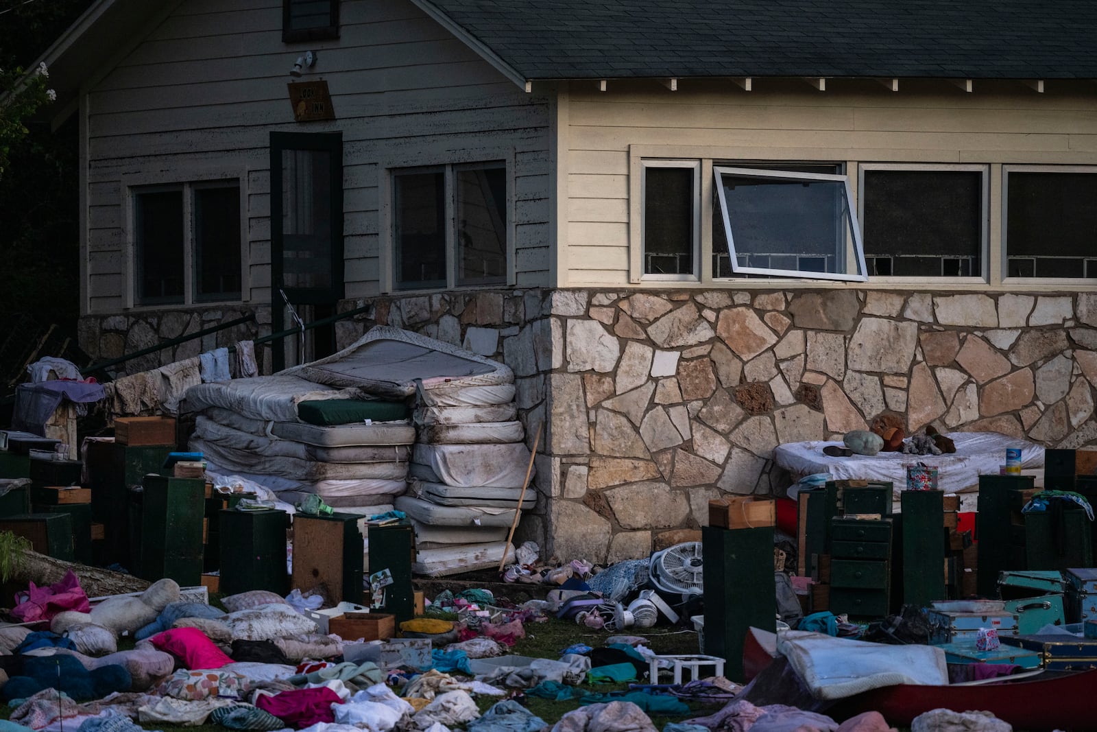 Camper's belongings sit outside one of Camp Mystic's cabins near the Guadalupe River after a flash flood swept through the area Monday, July 7, 2025, in Hunt, Texas. (AP Photo/Eli Hartman)