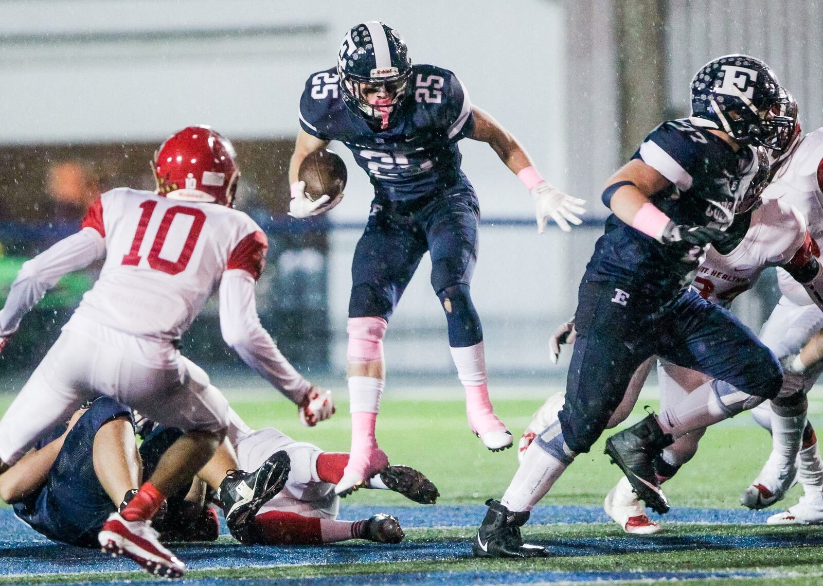 Edgewood’s Wade Phillips jumps over a Mount Healthy defender as he carries the ball Friday night at Kumler Field in St. Clair Township. NICK GRAHAM/STAFF