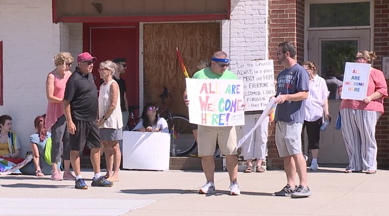 Protestors hold signs across from St. Mary Church in Oxford on Sunday, July 3, 2022. New priest Fr. David Doseck had penned a letter with what some called homophobic language.
 CONTRIBUTED/Kobe Gaines/WCPO