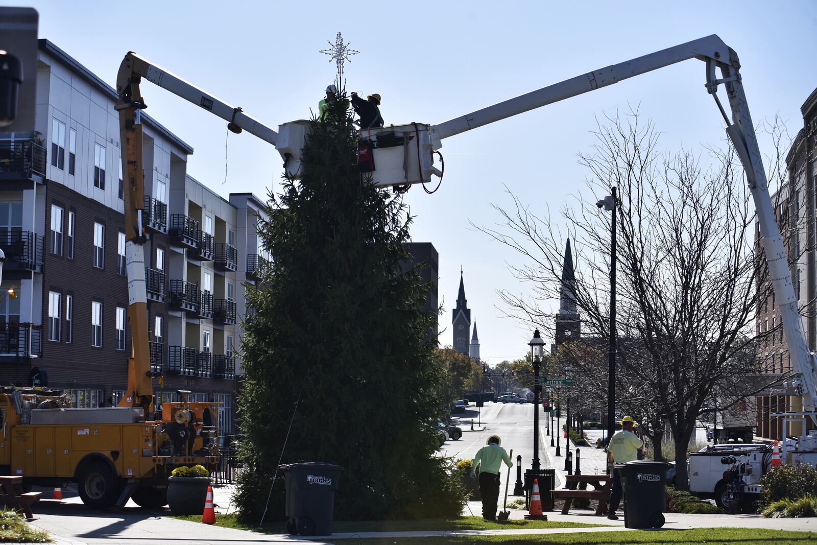 Hamilton city employees erect a Christmas tree at Marcum Park. The tree was donated by Gary and Donna Trudel of Hamilton. NICK GRAHAM/STAFF