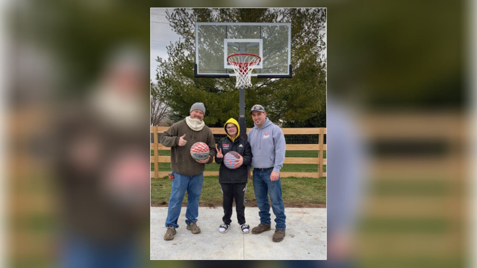 Kaden Buck, 17, of Trenton, stands with Hamilton firefighters Toby Howell and Ryan Pendergest, who helped organize an effort to build a basketball half-court space for the teen. PROVIDED