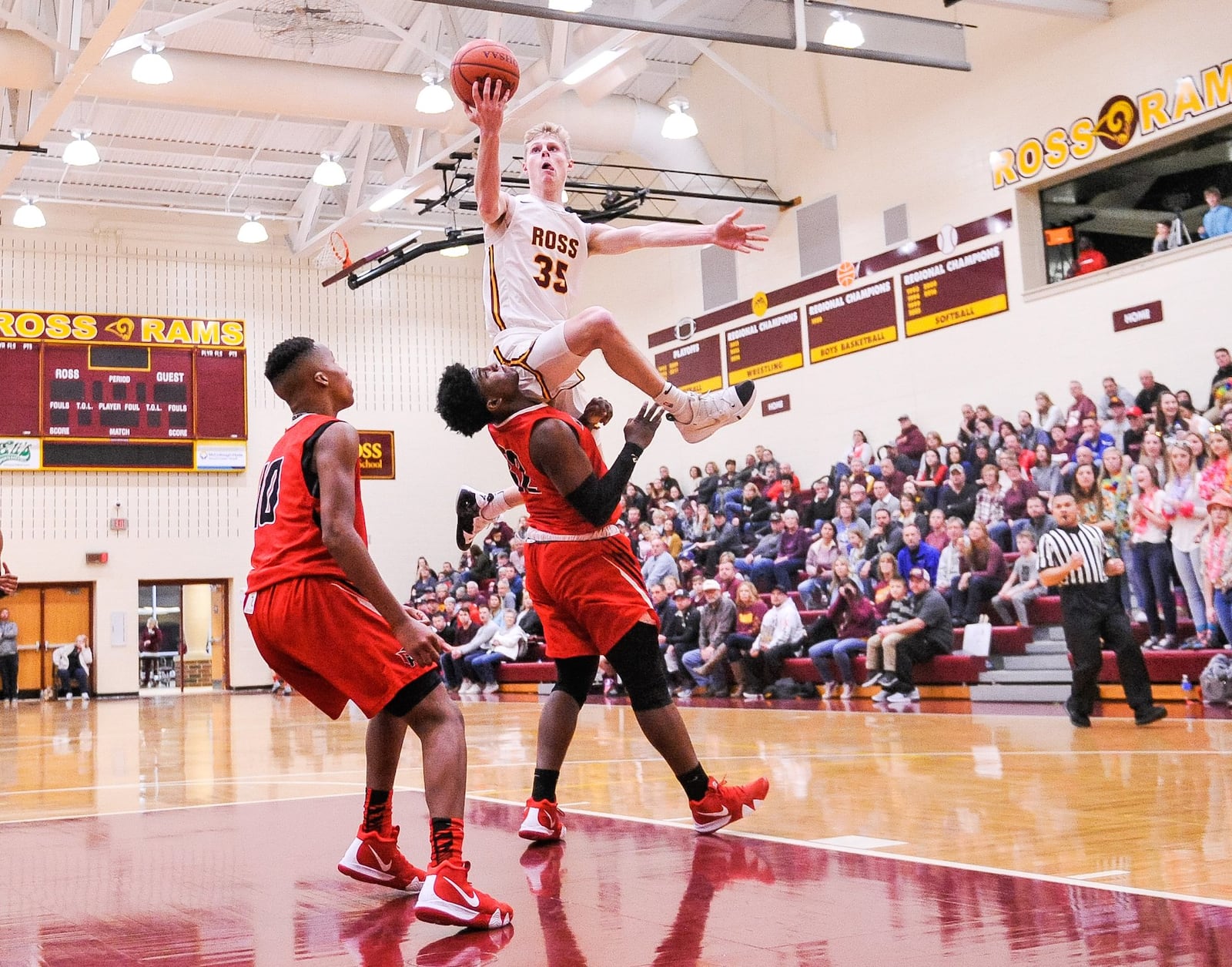 Cody Geers from Ross goes up for a shot over Mount Healthy’s Brandon Lanier during Tuesday night’s game at Ross. Mount Healthy won 65-46. NICK GRAHAM/STAFF