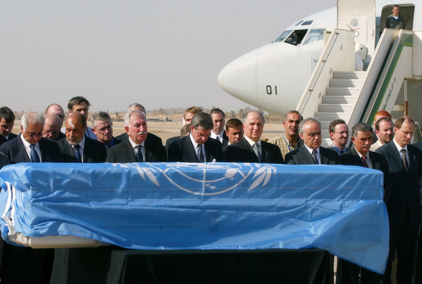 FILE - U.S. administrator in Iraq Paul Bremer, fourth left, along with UN and Iraqi officials pays last respects before Sergio Vieira de Mello's coffin, draped in a UN flag is loaded on a Brazilian presidential plane at Baghdad international airport, in Baghdad, Iraq, Aug. 22, 2003. Vieira de Mello, the top U.N. official in Iraq, was killed in a suicide truck bombing attack on U.N. headquarters that killed at least 22 other people and left more than 100 injured. (AP Photo/Manish Swarup, File)