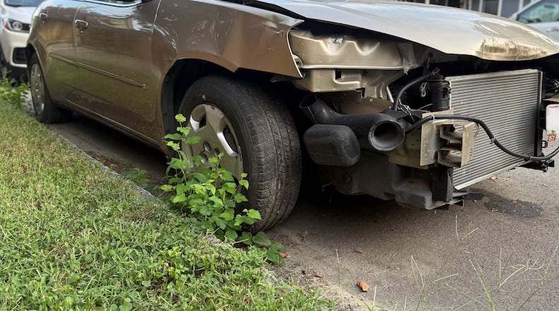 A damaged car parked on a residential street in the city of Dayton. CORNELIUS FROLIK / STAFF