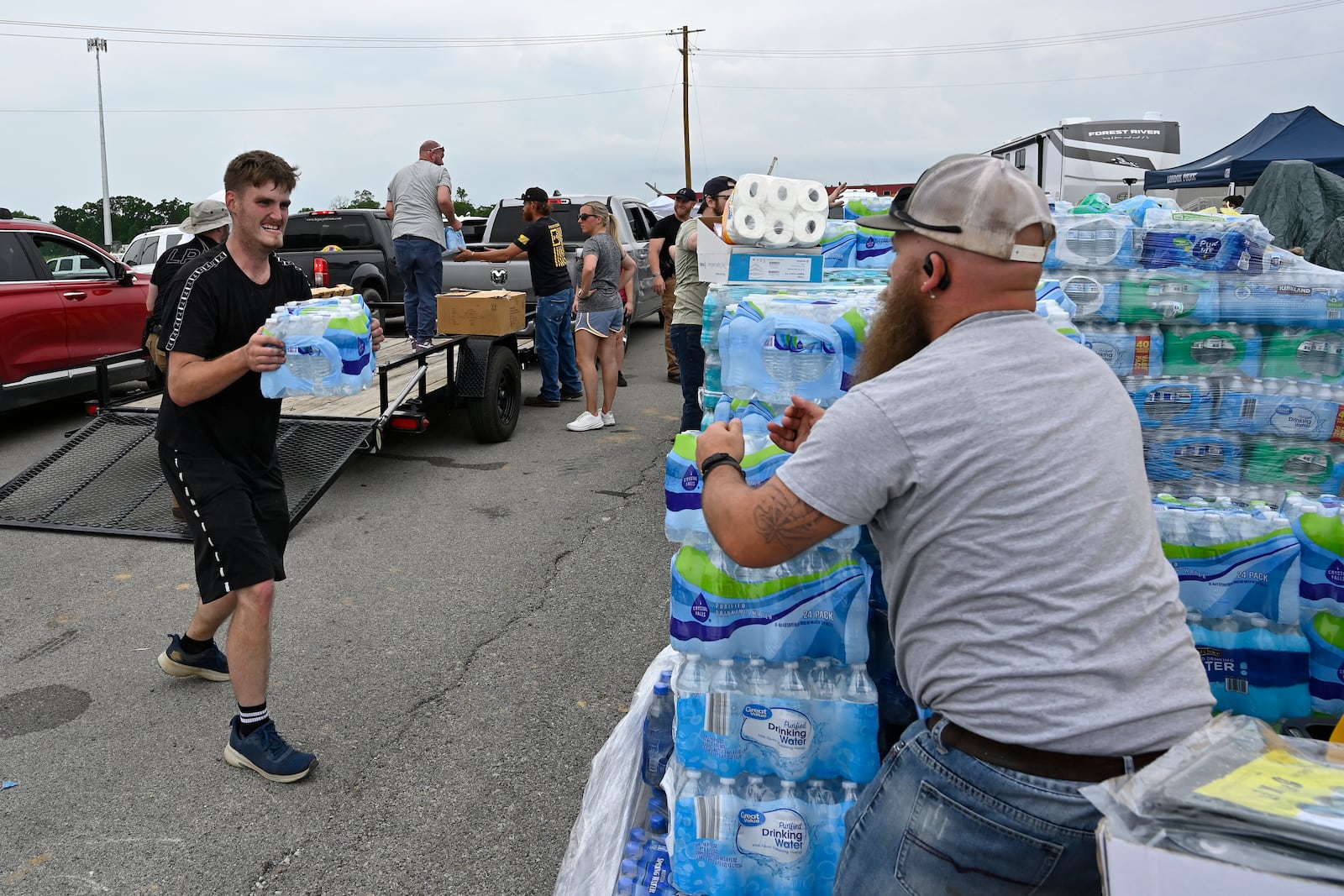 Volunteers deliver water to a command center at the London-Corbin Airport in London, Ky., Monday, May 19, 2025. (AP Photo/Timothy D. Easley)