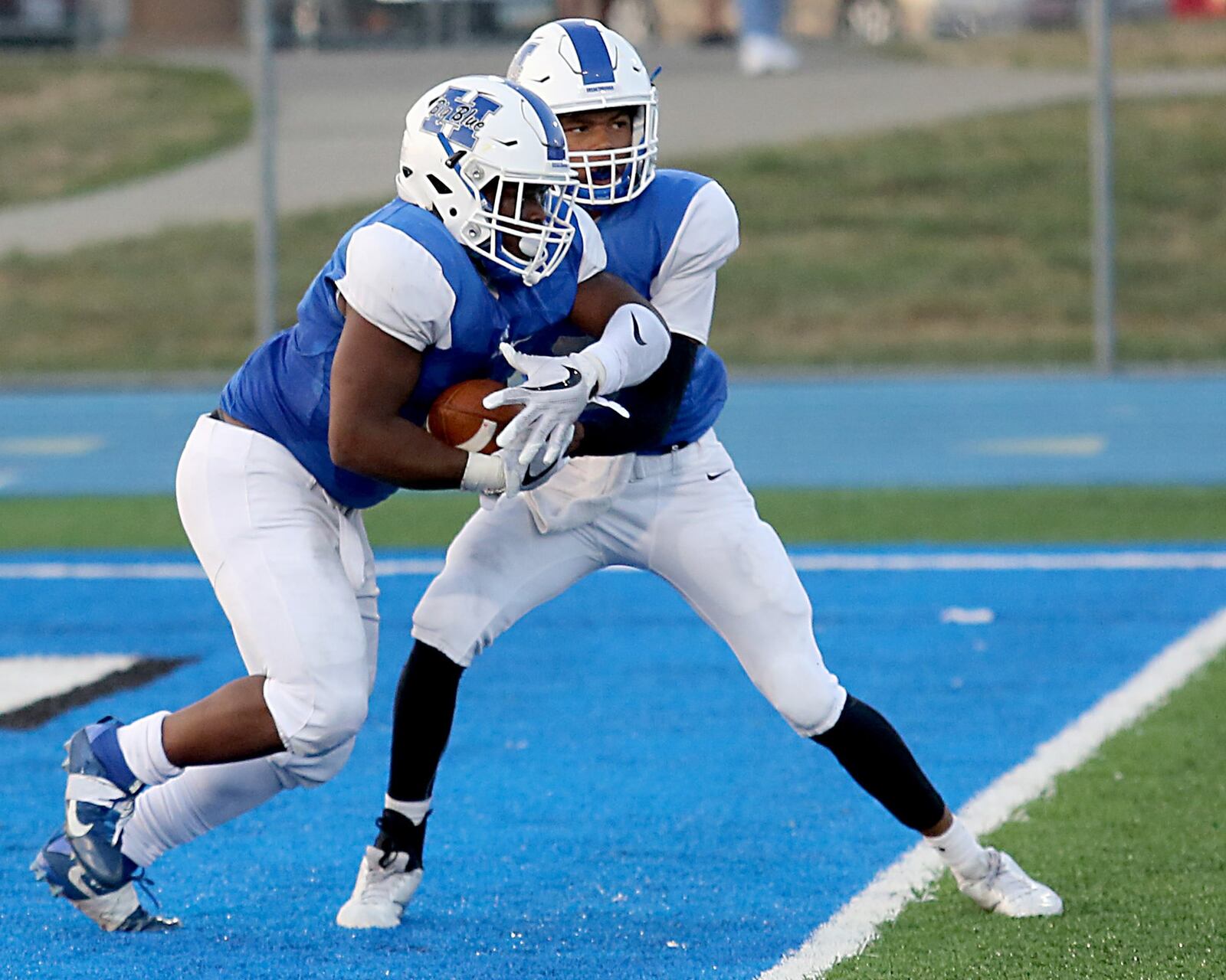Hamilton’s Maleek Jarrett takes a handoff from Khaliyal Sowell on Saturday night during a Skyline Chili Crosstown Showdown contest against Moeller at Virgil Schwarm Stadium in Hamilton. CONTRIBUTED PHOTO BY E.L. HUBBARD