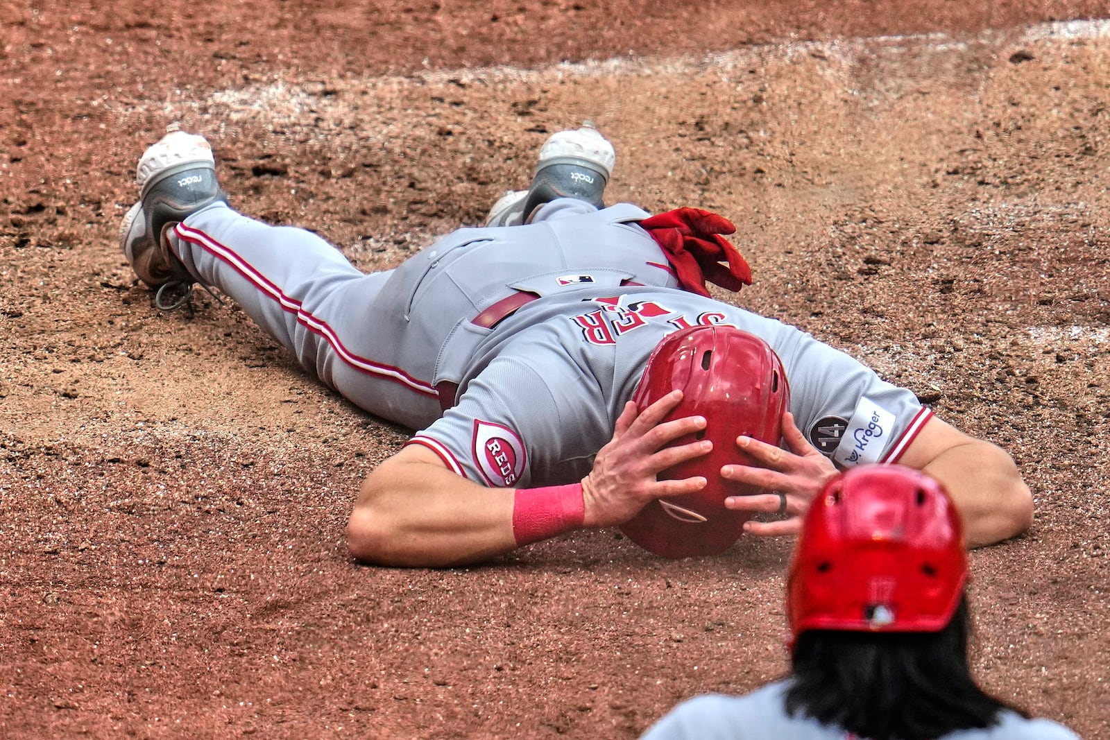 Cincinnati Reds' Spencer Steer collects himself after being tagged out by Pittsburgh Pirates catcher Henry Davis while attempting to score on a double by Tyler Stephenson during the sixth inning of a baseball game in Pittsburgh, Wednesday, May 21, 2025. (AP Photo/Gene J. Puskar)