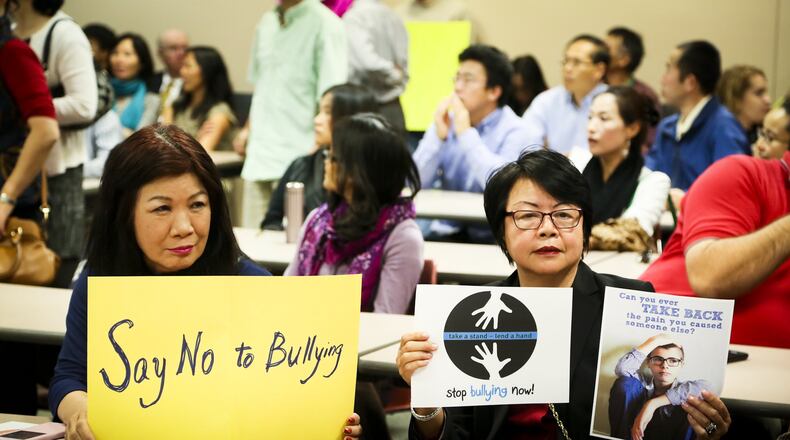 Louisa Luk and Gail Young hold signs against bullying during the Fairfield School Board meeting Thursday, Oct. 15, 2015. A large crowd was present to protest the the ongoing bullying at Fairfield Middle School and the lack of action by administrators. GREG LYNCH / STAFF