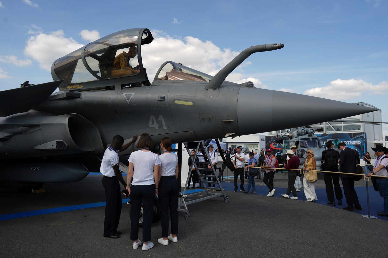 Visitors watch a Rafale fighter jet at the Paris Air Show, Monday, June 16, 2025 in Le Bourget, north of Paris. (AP Photo/Thibault Camus)
