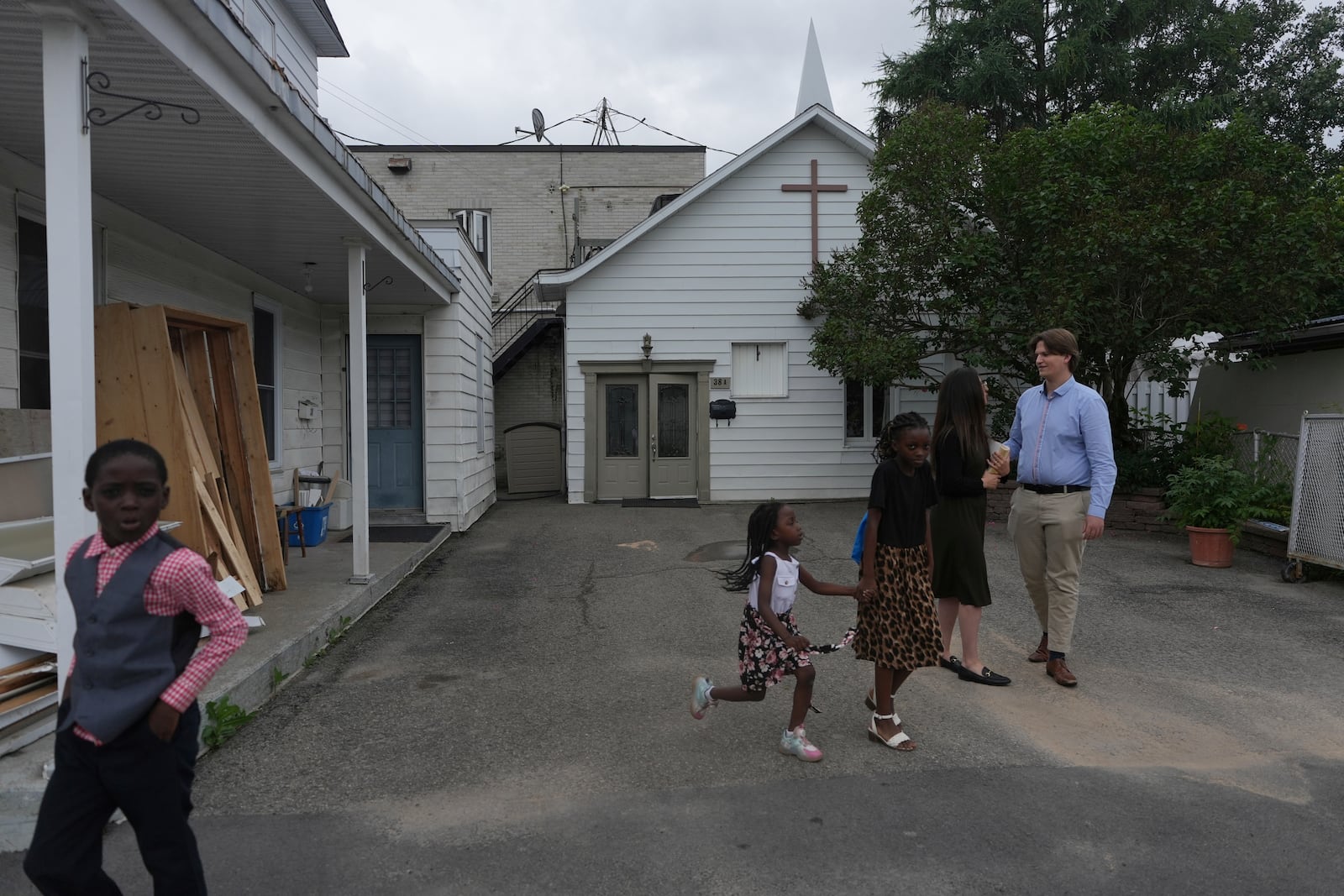 Children play while Megane Ares-Dube and her husband, Raphael Lapointe, talk after attending service at the Reformed Baptist Church in Saint Jerome, Quebec, Sunday, June 29, 2025. (AP Photo/Luis Andres Henao)