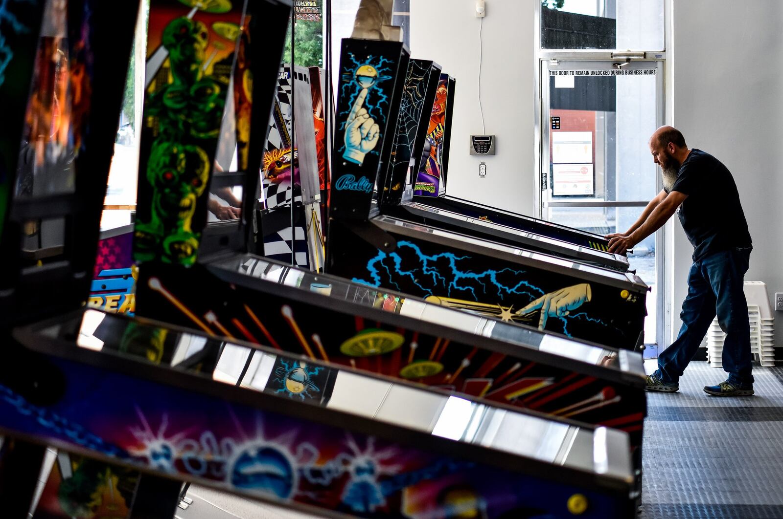 Pinball Garage owner Brad Baker plays the brand new Teenage Mutant Ninja Turtles pinball game Thursday, June 25, 2020. Pinball Garage is now open in downtown Hamilton and offers a large selection of pinball machines to play along with a bar with rotating beer selection. NICK GRAHAM / STAFF