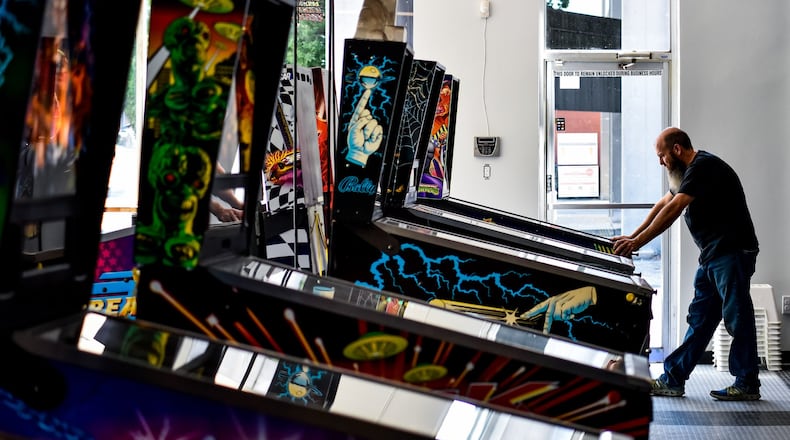 Pinball Garage owner Brad Baker plays the brand new Teenage Mutant Ninja Turtles pinball game Thursday, June 25, 2020. Pinball Garage is now open in downtown Hamilton and offers a large selection of pinball machines to play along with a bar with rotating beer selection. NICK GRAHAM / STAFF