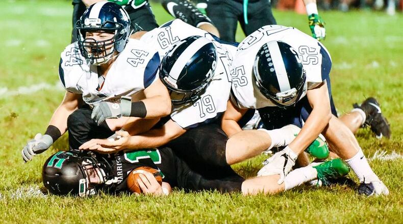 Edgewood’s Dylan Polisini (44), Clayton Gerber (79) and Tyler Began (52) take Harrison quarterback Connor Kinnett to the ground during Friday night’s game at Bill Kuntz Field in Harrison. The visiting Cougars won 42-35 to remain unbeaten. NICK GRAHAM/STAFF