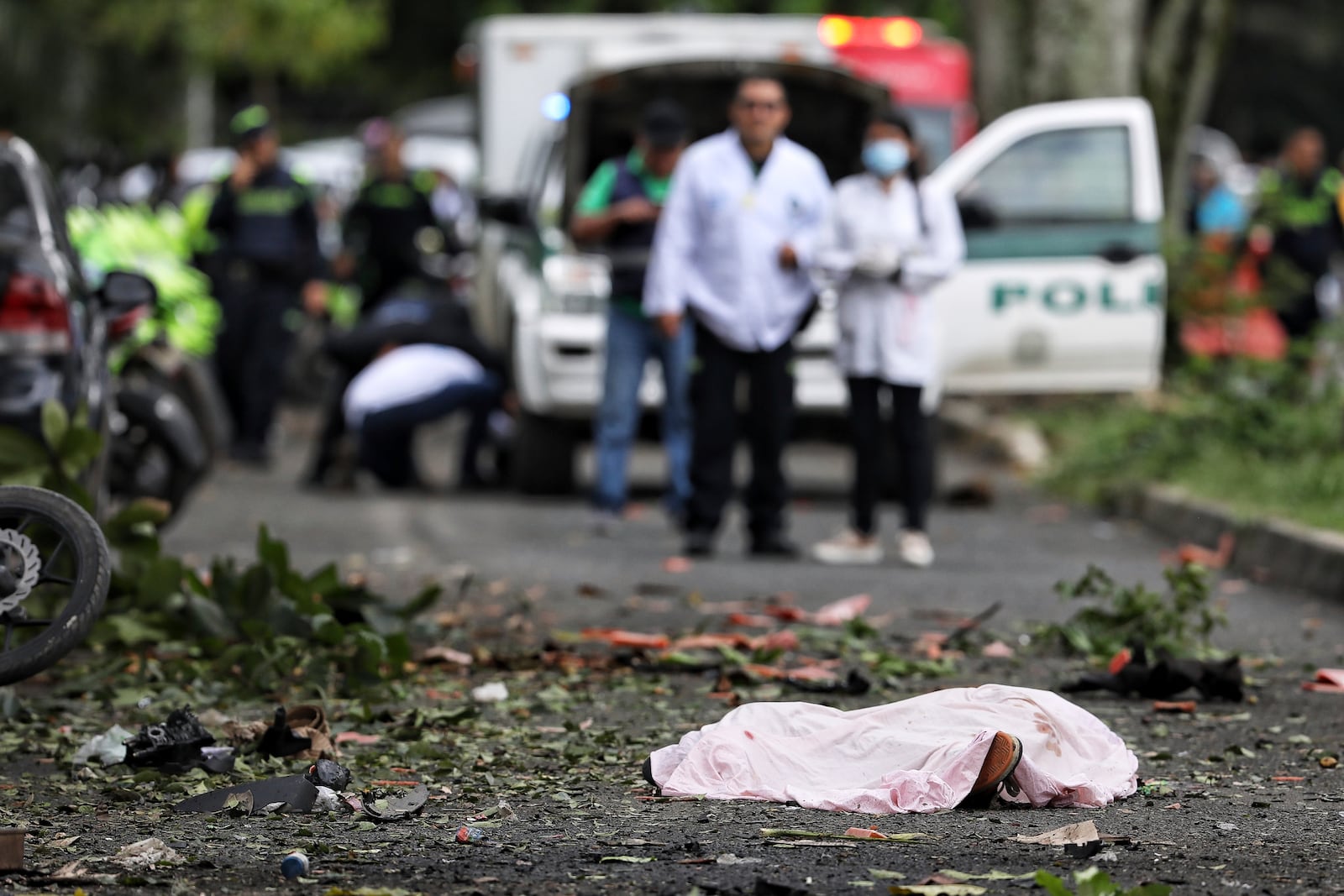 A body lies in the street, covered by a sheet, after a bomb explosion in Cali, Colombia, Tuesday, June 10, 2025. (AP Photo/Santiago Saldarriaga)